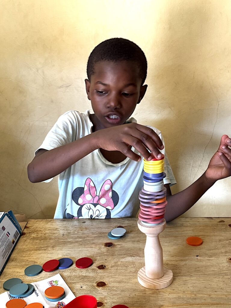 TEDS COMMUNITY HUB Ein Kind spielt mit Holzspielzeug in der Library von Teds Community Hub.